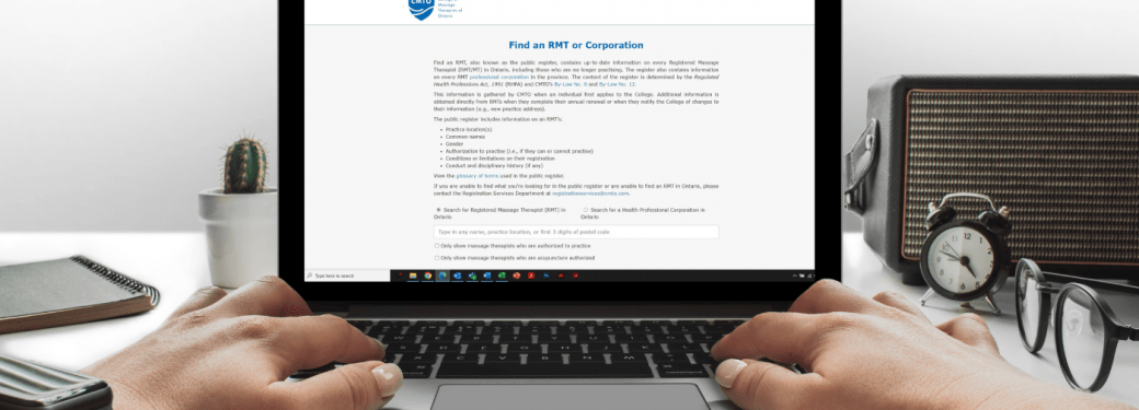 Hands typing on a laptop displaying the "Find an RMT or Corporation" webpage from the College of Massage Therapists of Ontario.